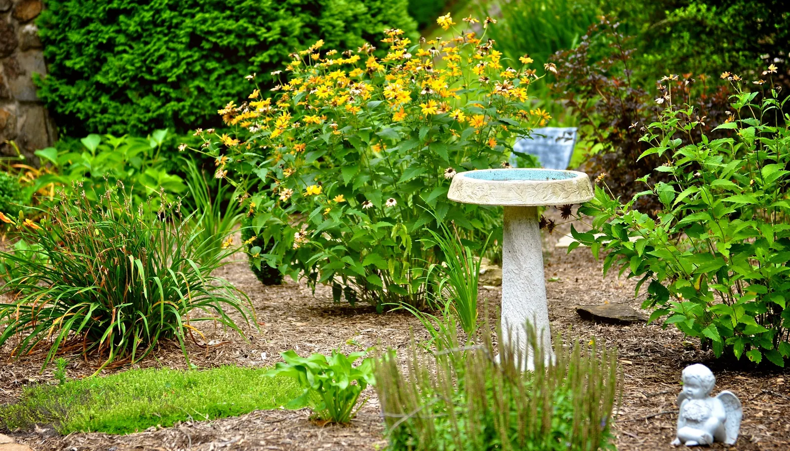 Flower gardens and a birdbath at the park